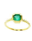 A medium green Colombian emerald ring bezel set with a tapered bezel set in a 14K gold band
