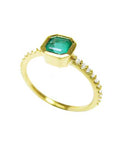 From a partial side angle, this emerald ring displays the top setting, and the band design.