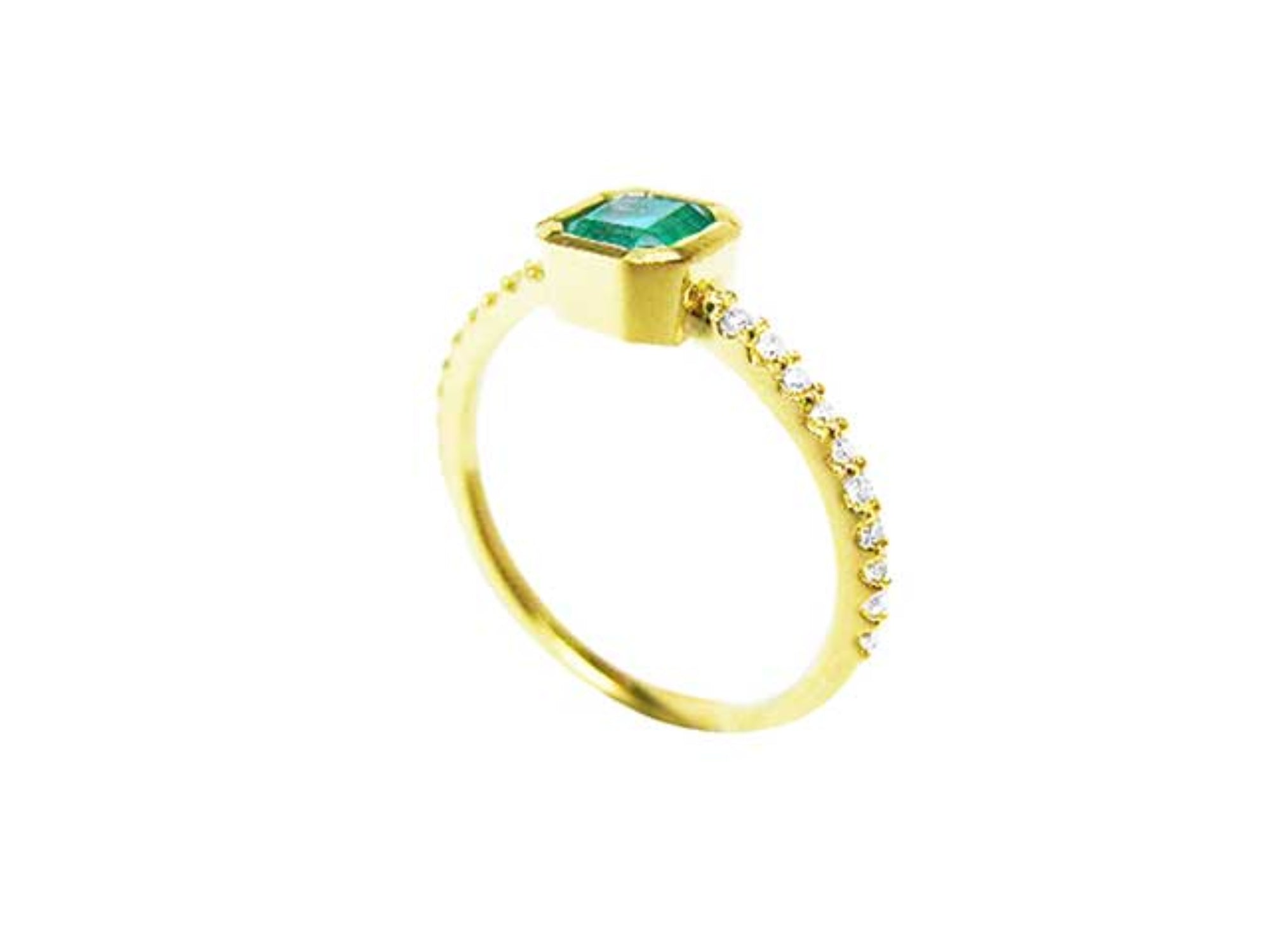 A yellow gold ring with a bezel set emerald in a partial side view on a white background.