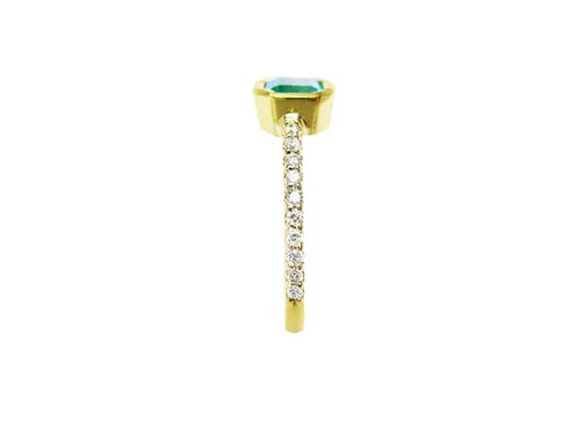 A clean side profile perspective of this natural emerald ring crafted in 14k yellow gold.