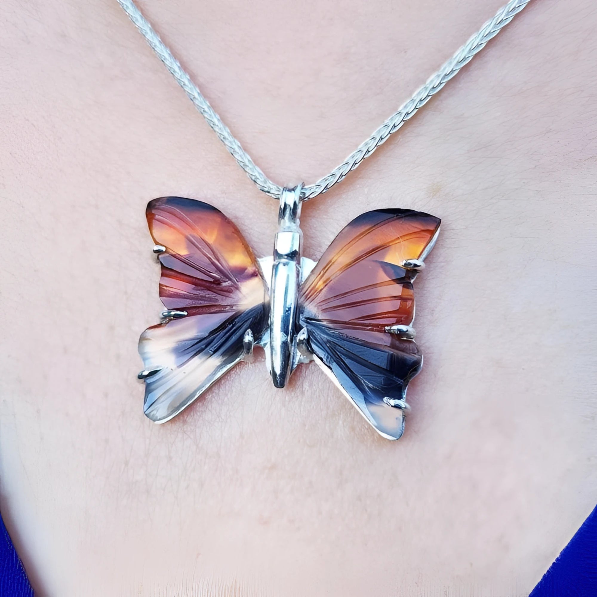 Agate butterfly pendant necklace in orange, brown, and black, set in sterling silver.