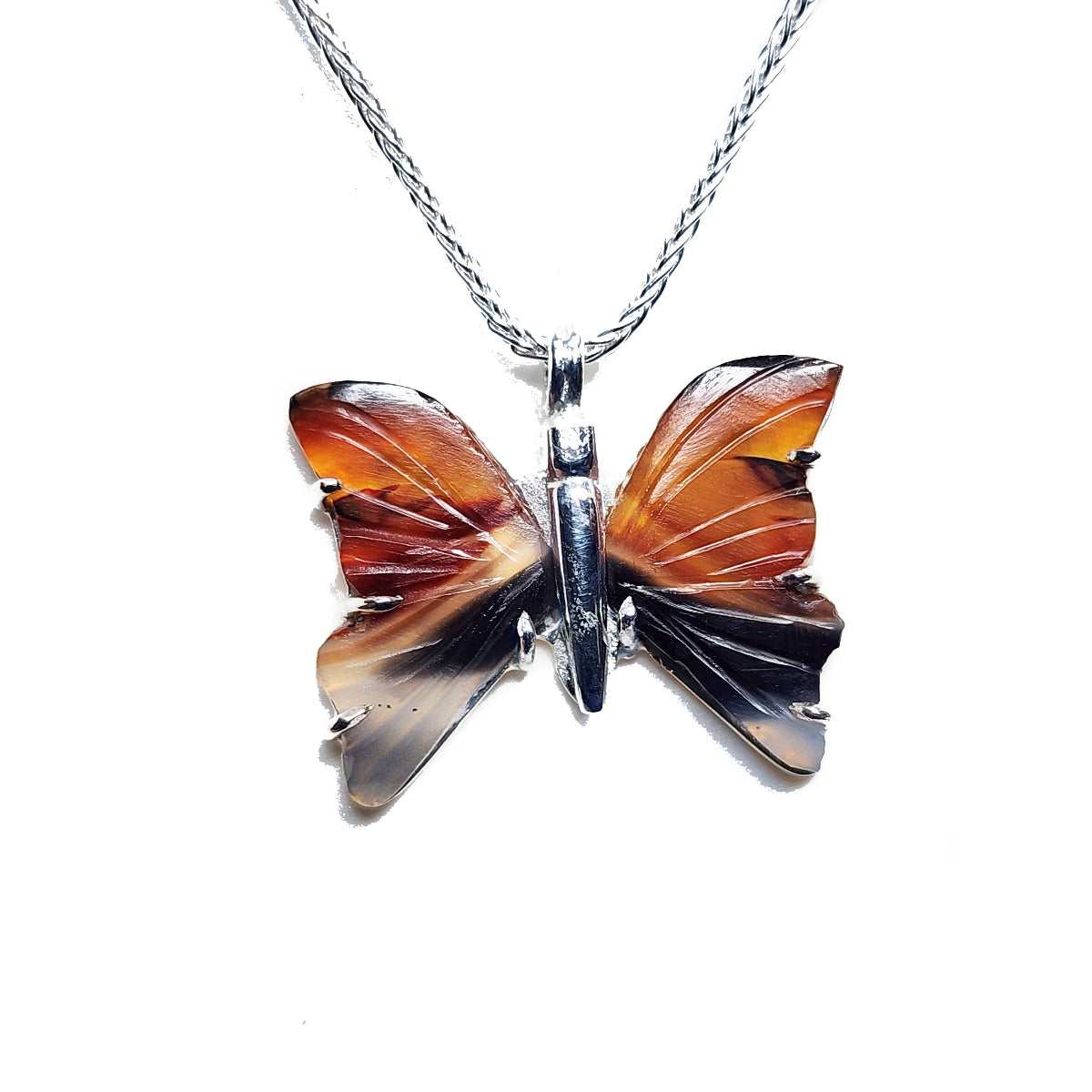 Butterfly-shaped agate pendant silver on a chain against a white background