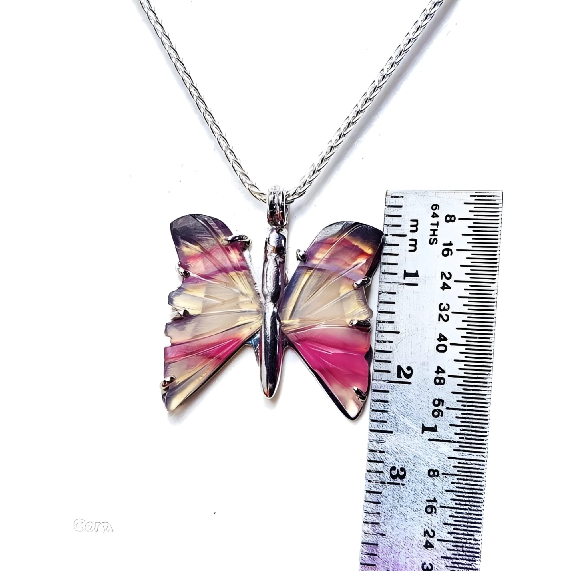 Handcrafted butterfly agate pendant necklace with rich pink wings and sterling silver chain, shown with ruler for size.