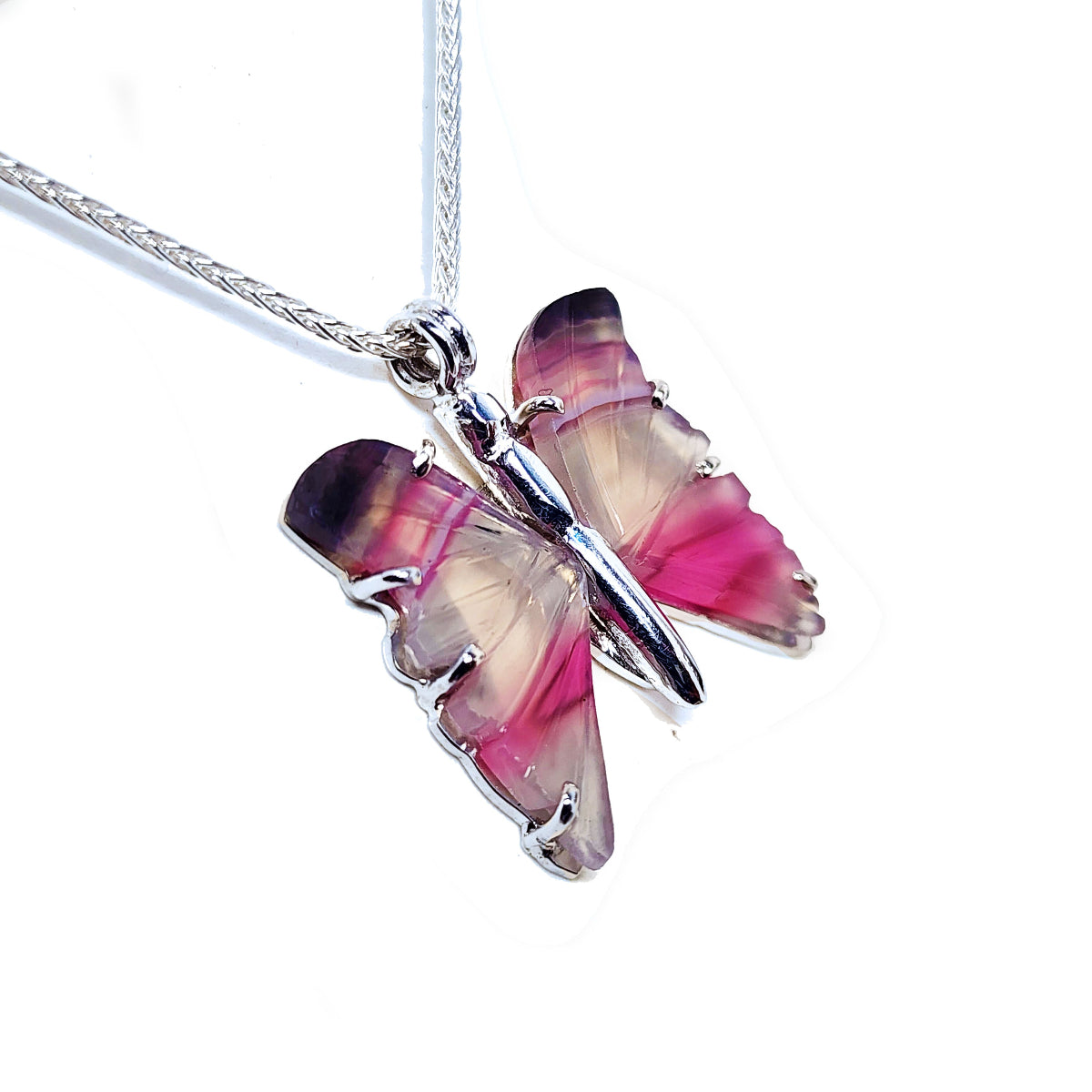 Agate butterfly-shaped sterling silver pendant with pink and purple wings on a white background