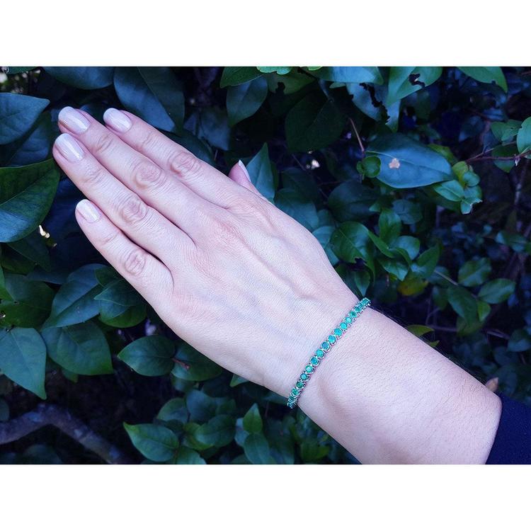 Hand modeling a 14K white gold tennis bracelet with sparkling round Colombian emeralds.