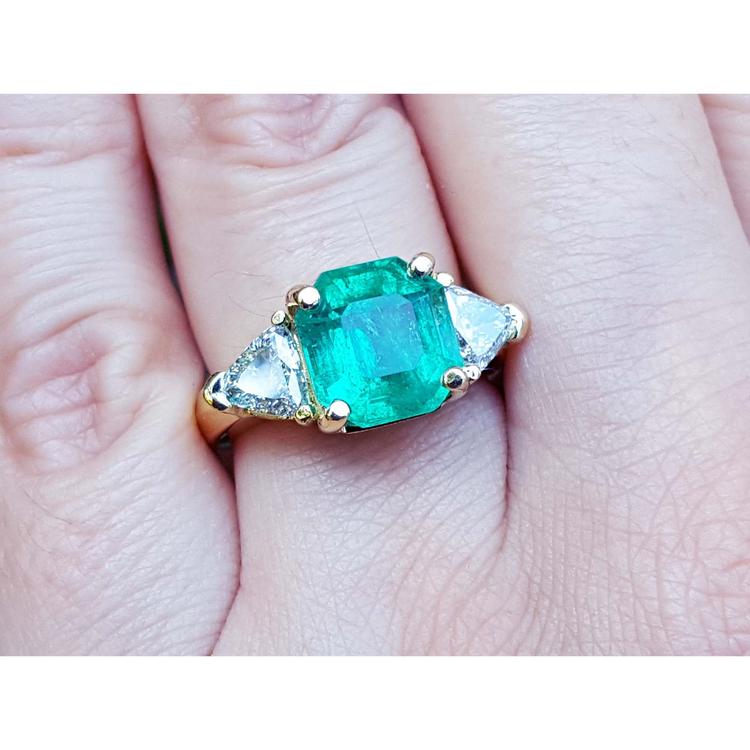 Anillo de oro 18k con esmeralda colombiana verde brillante de 4.16 ct y diamantes laterales.