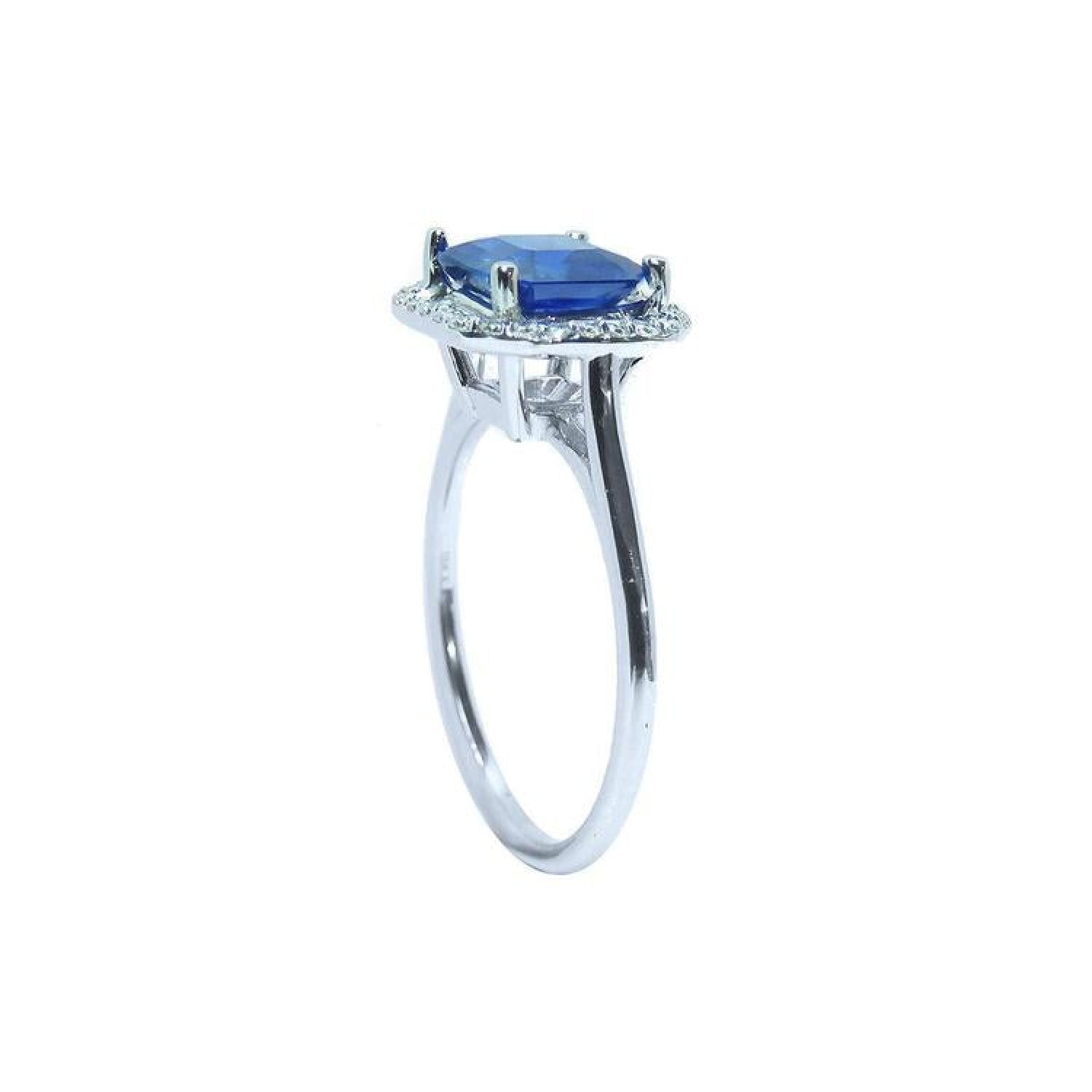 Asscher cut blue sapphire ring with halo diamonds in 18k white gold.