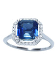Asscher cut blue sapphire ring for women 18k white gold, sparkling medium dark blue color prong set with halo natural diamonds.