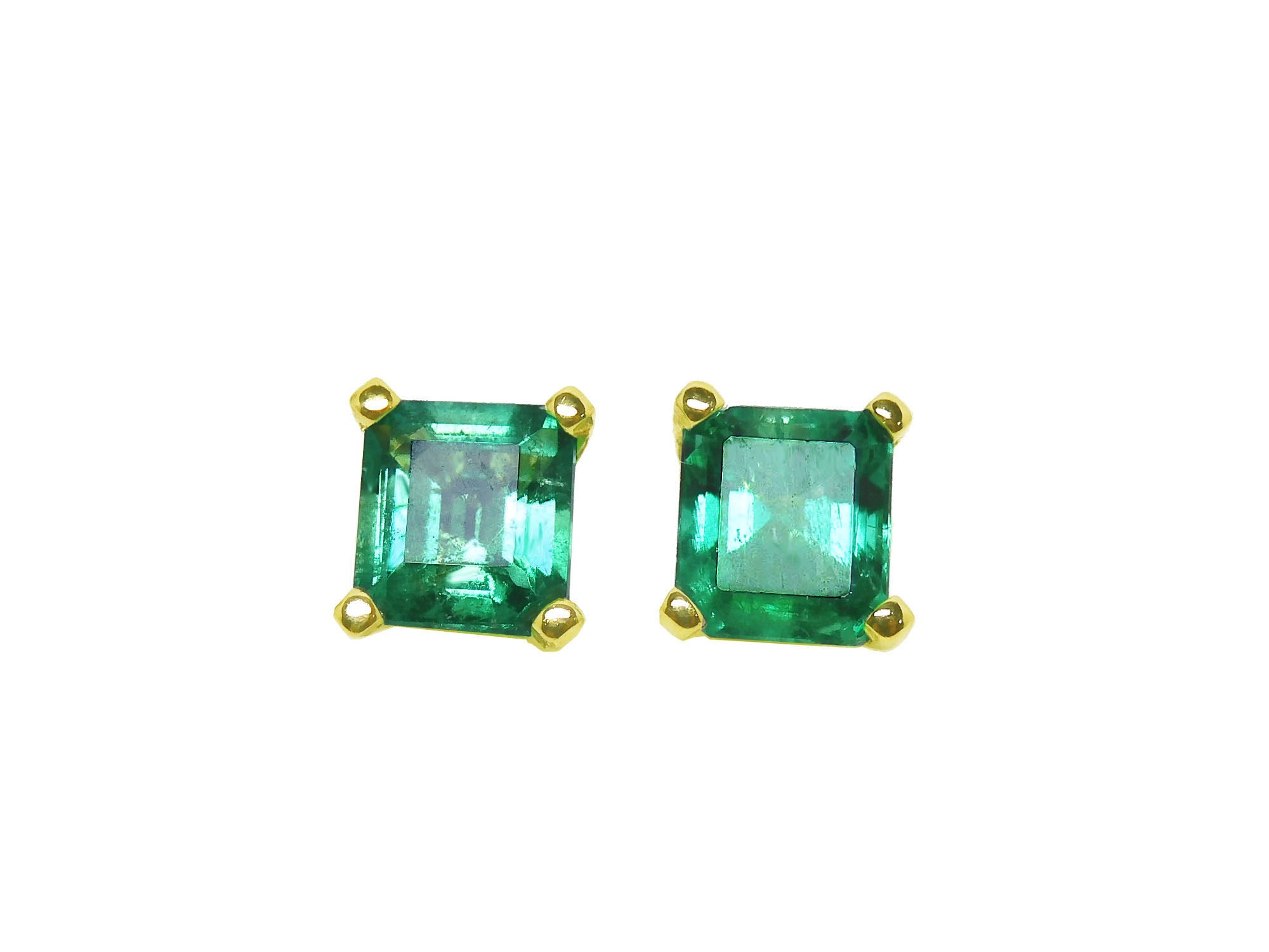 Pair of ascher cut emerald stud earrings with gold settings on a front side position top view.