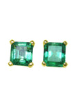 Pair of ascher cut emerald stud earrings with gold settings on a front side position top view.