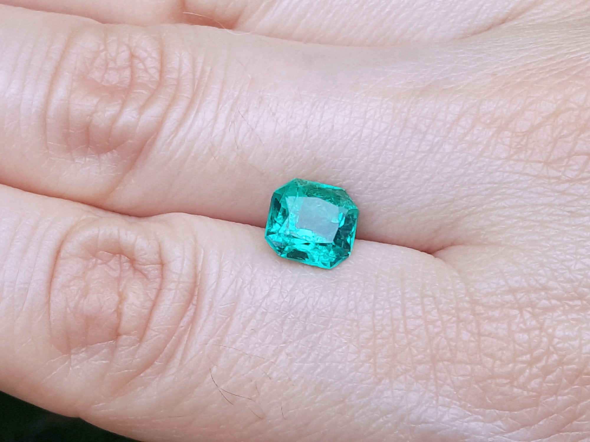 Gia certified loose emerald square modified brilliant cut on hand display