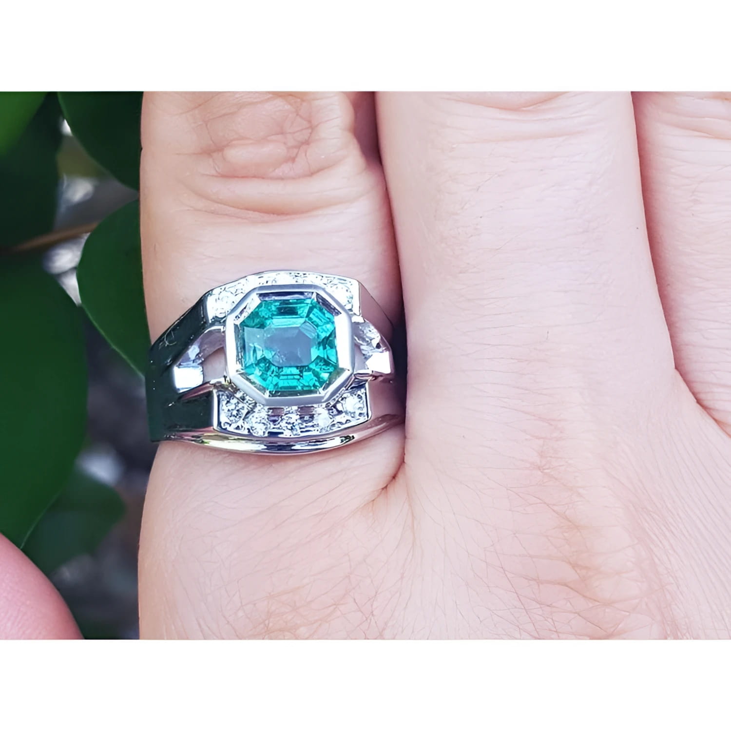 Men's 18K white gold ring with a vibrant asscher-cut emerald and diamond accents.