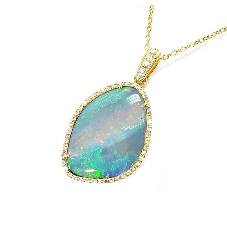 Opal pendant necklace with gold chain on a left-side profile view.