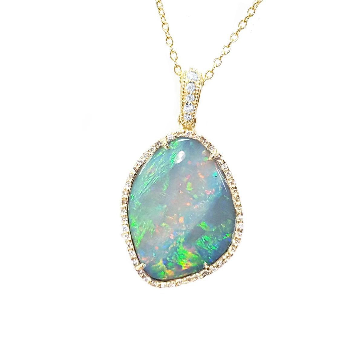 Opal pendant necklace with gold chain on a topside position displaying the frame with diamonds.
