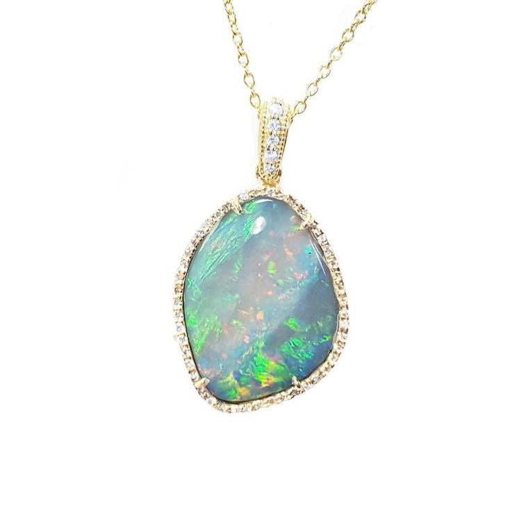 Opal pendant necklace with gold chain on a topside position displaying the frame with diamonds.