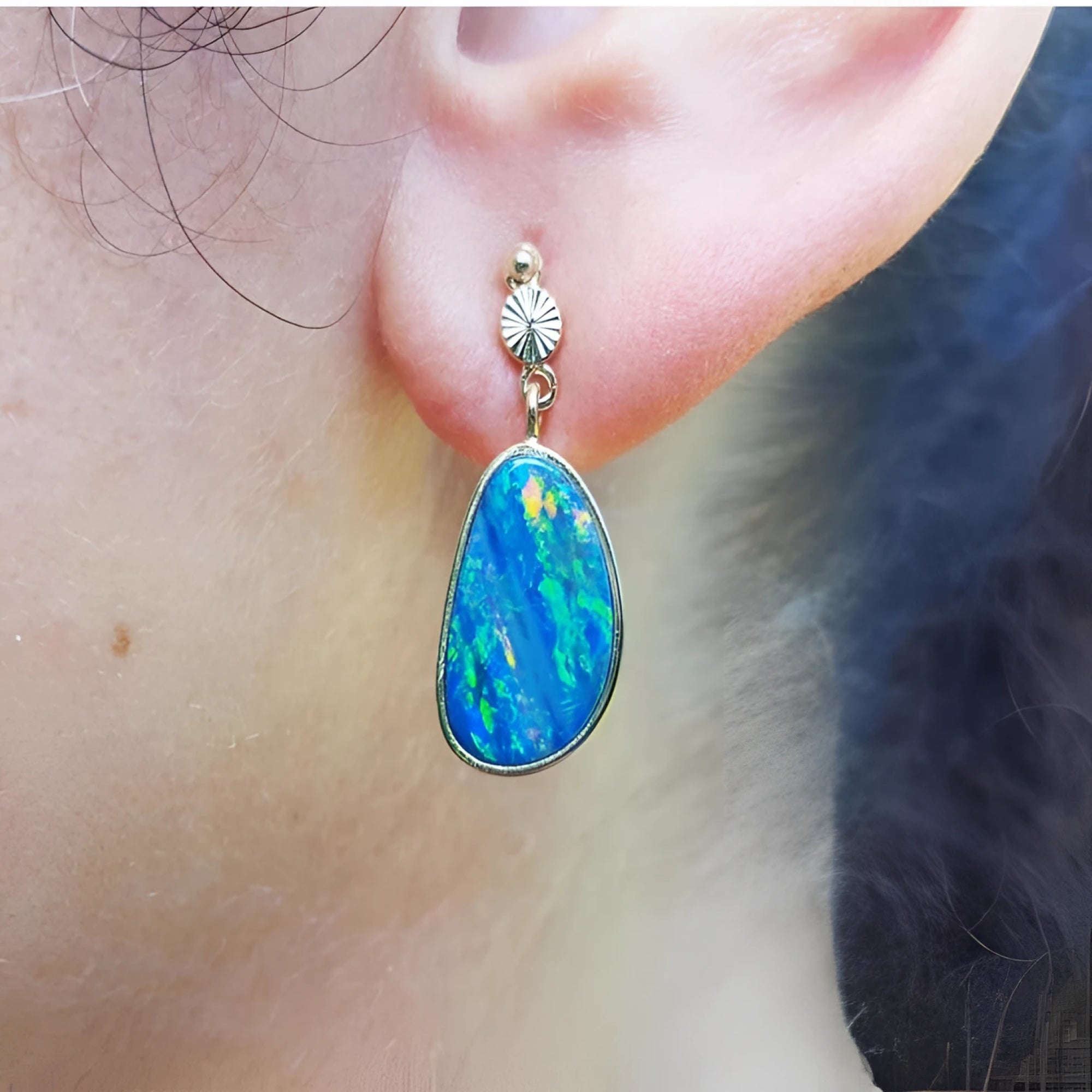Australian opal doublet dangle earring in 14K yellow gold, featuring a vibrant blue and green opal in a bezel setting.