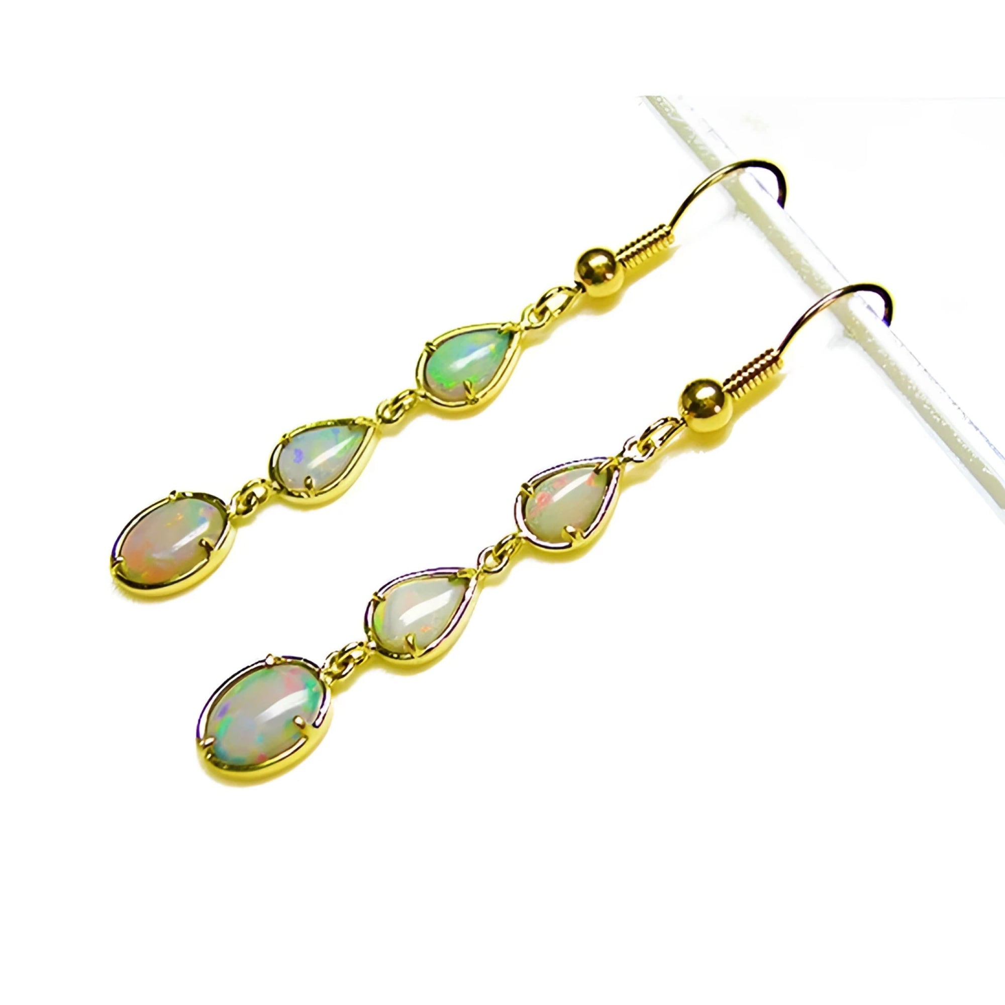 Handcrafted 14k yellow gold dangle earrings with three pear and oval-shaped Australian opals.