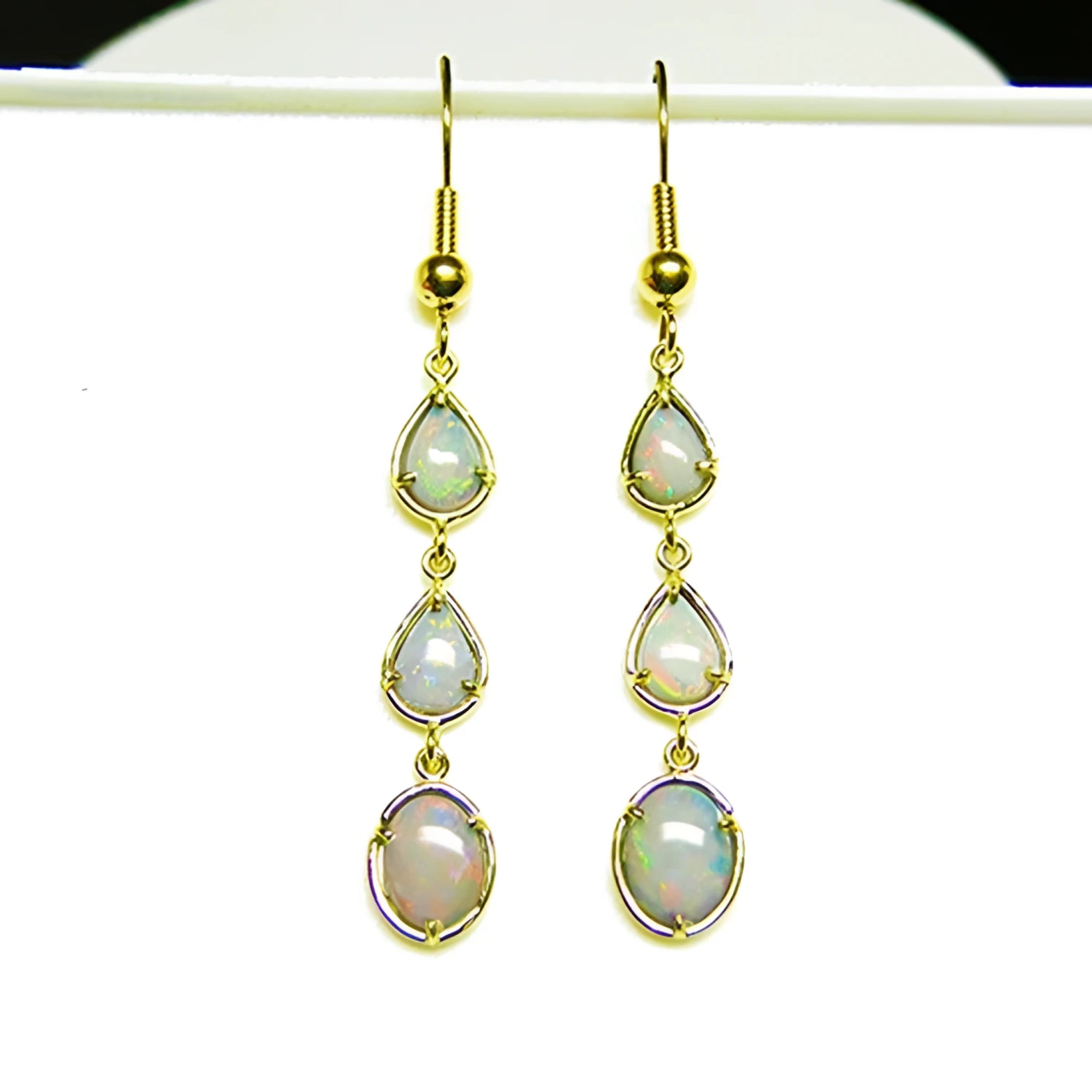 Pear and oval Australian opal dangle earrings in 14k yellow gold.