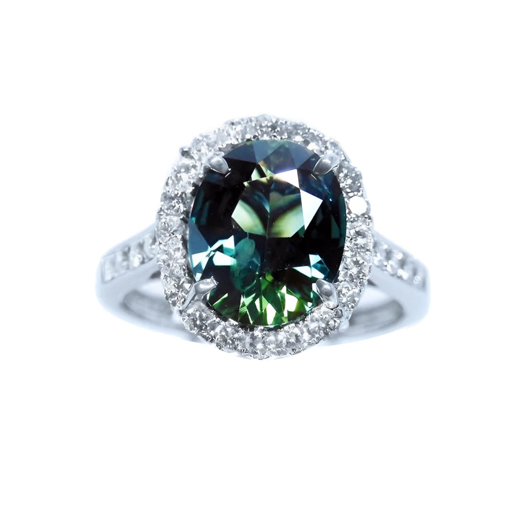 Australian sapphire ring for women oval cut with a sparkling bluish green hue, in a halo diamond crafted in 18K white gold. 