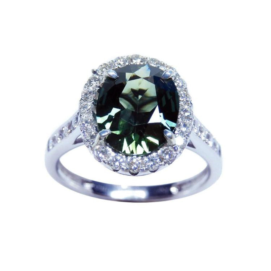 Oval bluish-green Australian sapphire ring with diamond halo and band in 18K white gold.