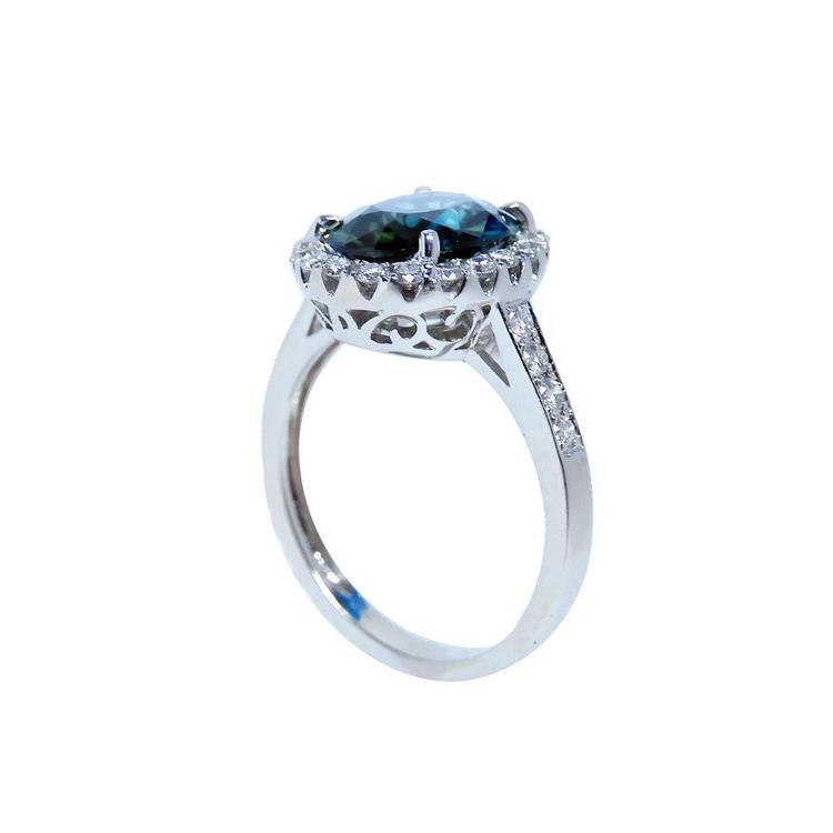 18K white gold ring with a large oval bluish-green Australian sapphire surrounded by a diamond halo.