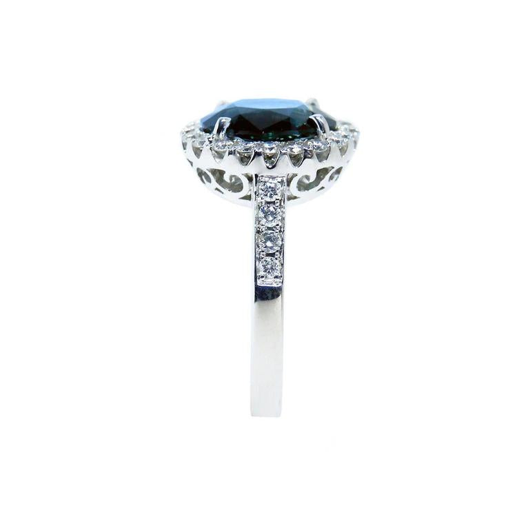 18K white gold ring with a large oval bluish-green Australian sapphire haloed by diamonds.