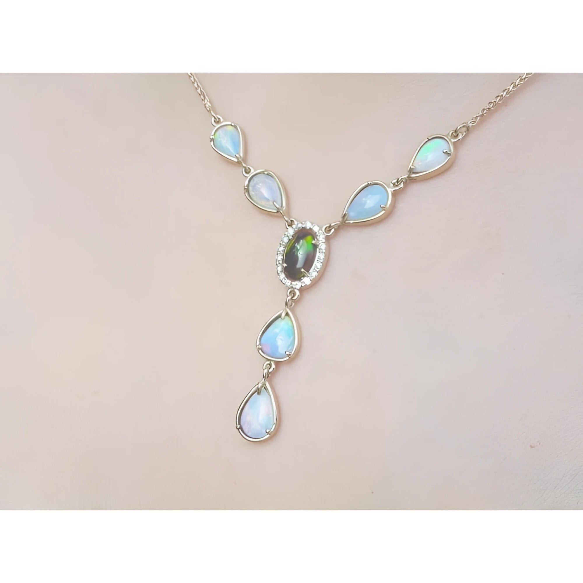 14k yellow gold necklace with a black Australian opal haloed by diamonds, surrounded by teardrop opals.