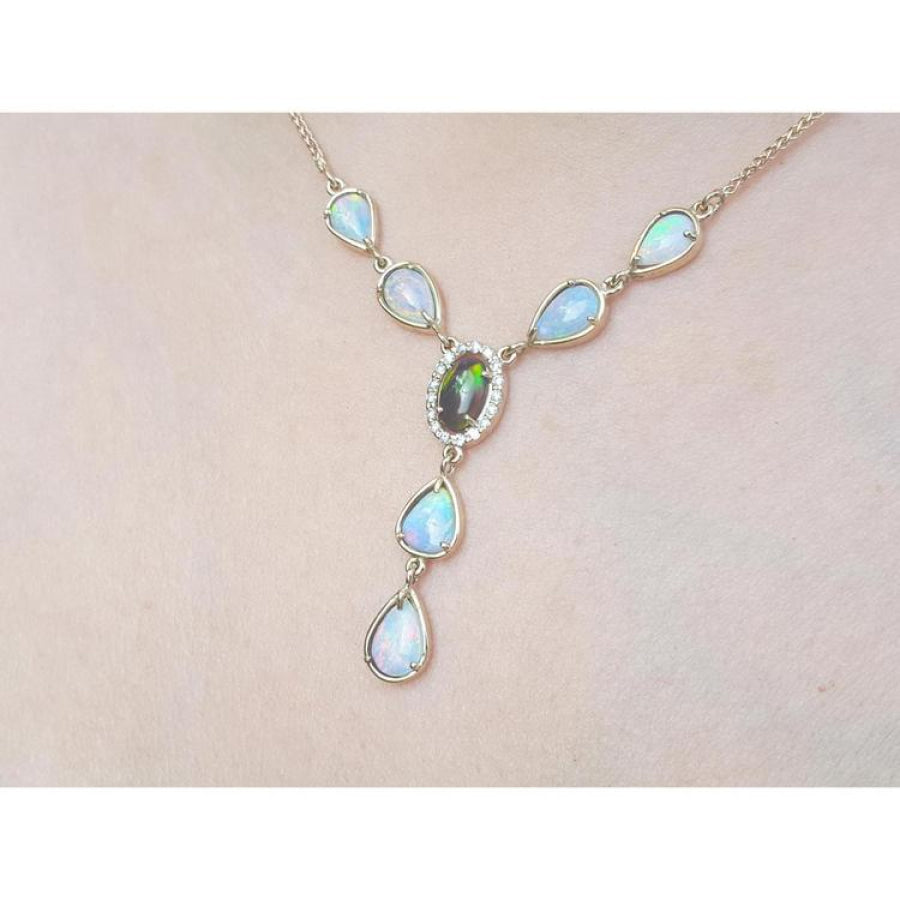 14k yellow gold necklace with a black Australian opal haloed by diamonds, surrounded by teardrop opals.