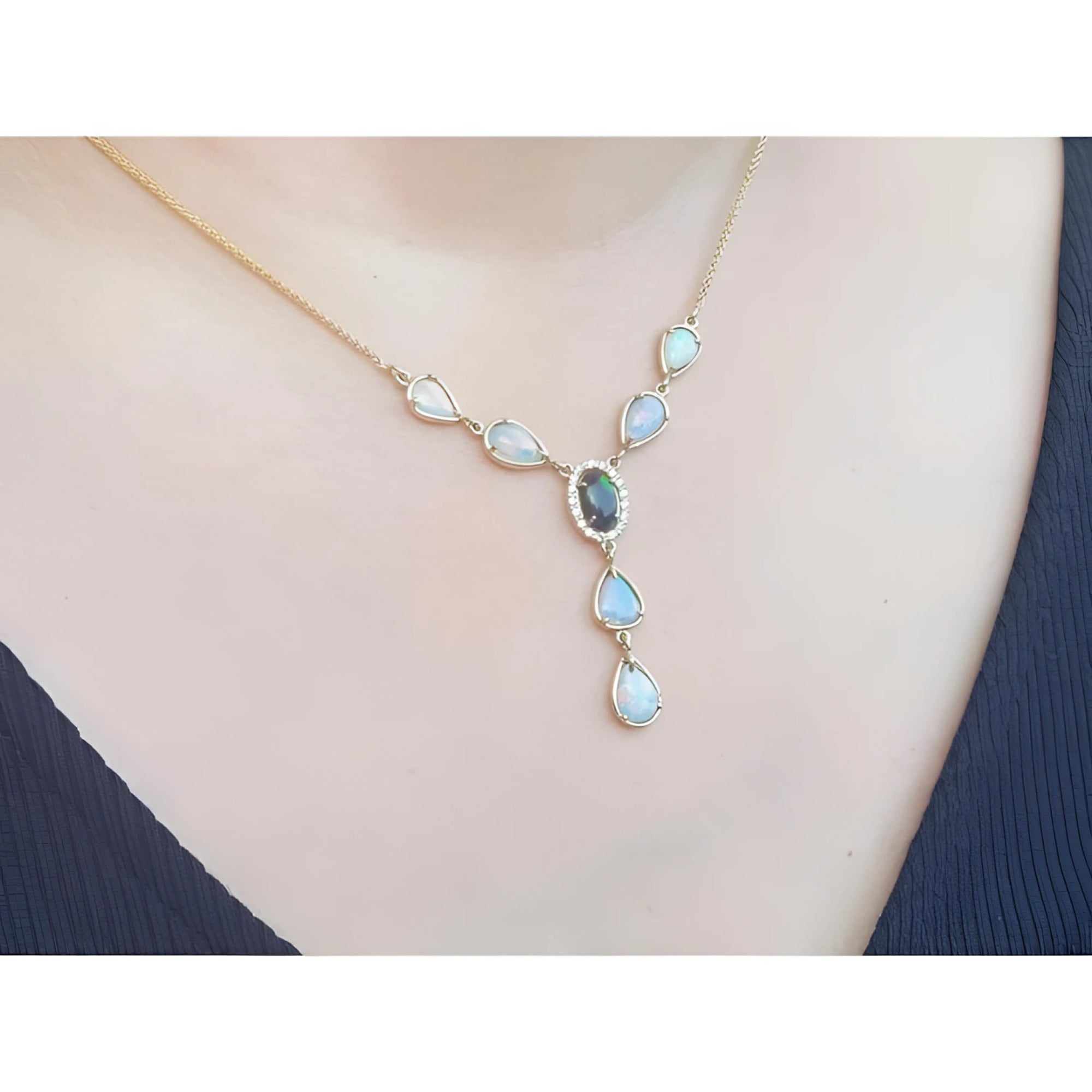 14k yellow gold necklace with a black opal center, diamond halo, and teardrop opals.