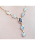 Necklace with opal stones on a light pink background