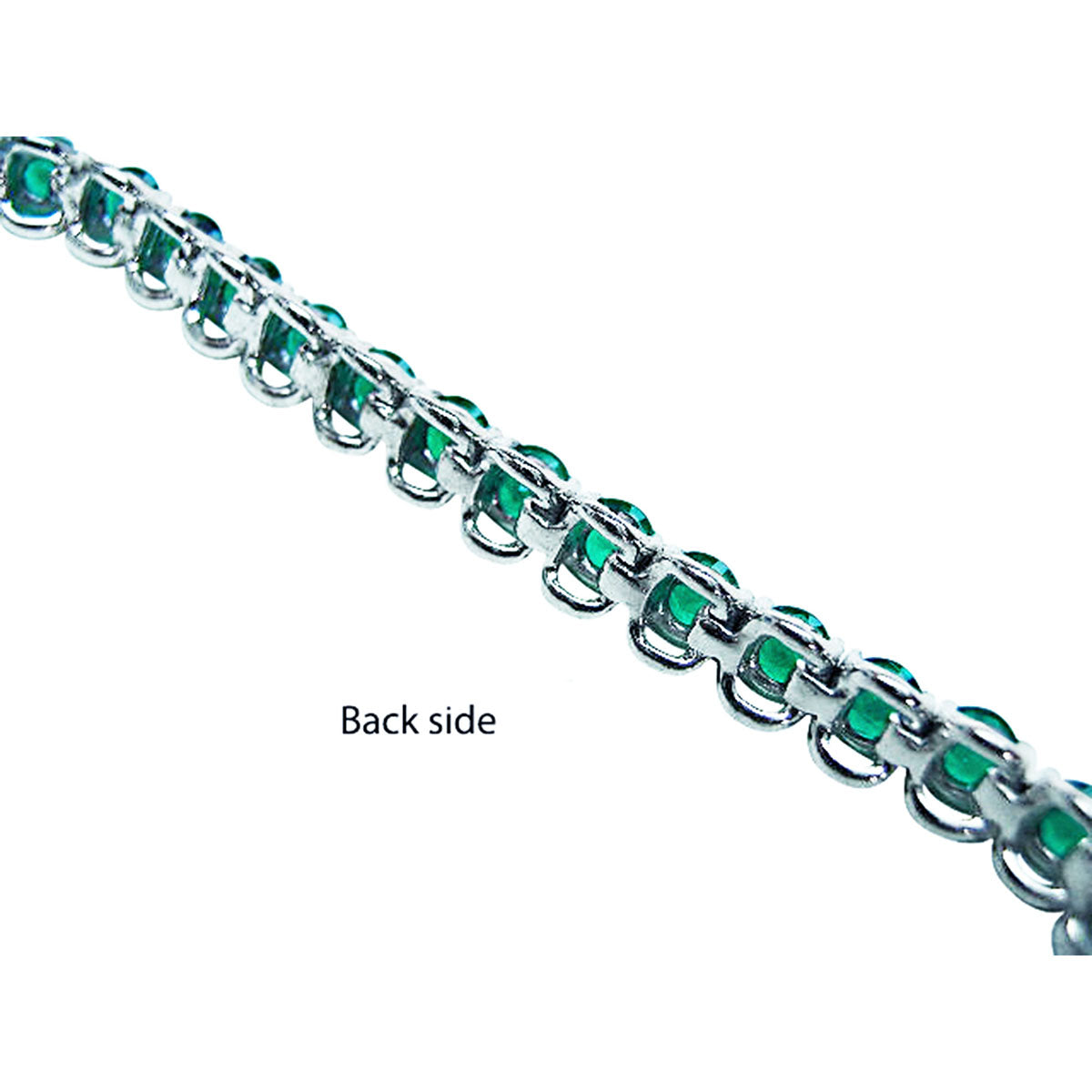 The backside profile view of a white gold emerald tennis bracelet.