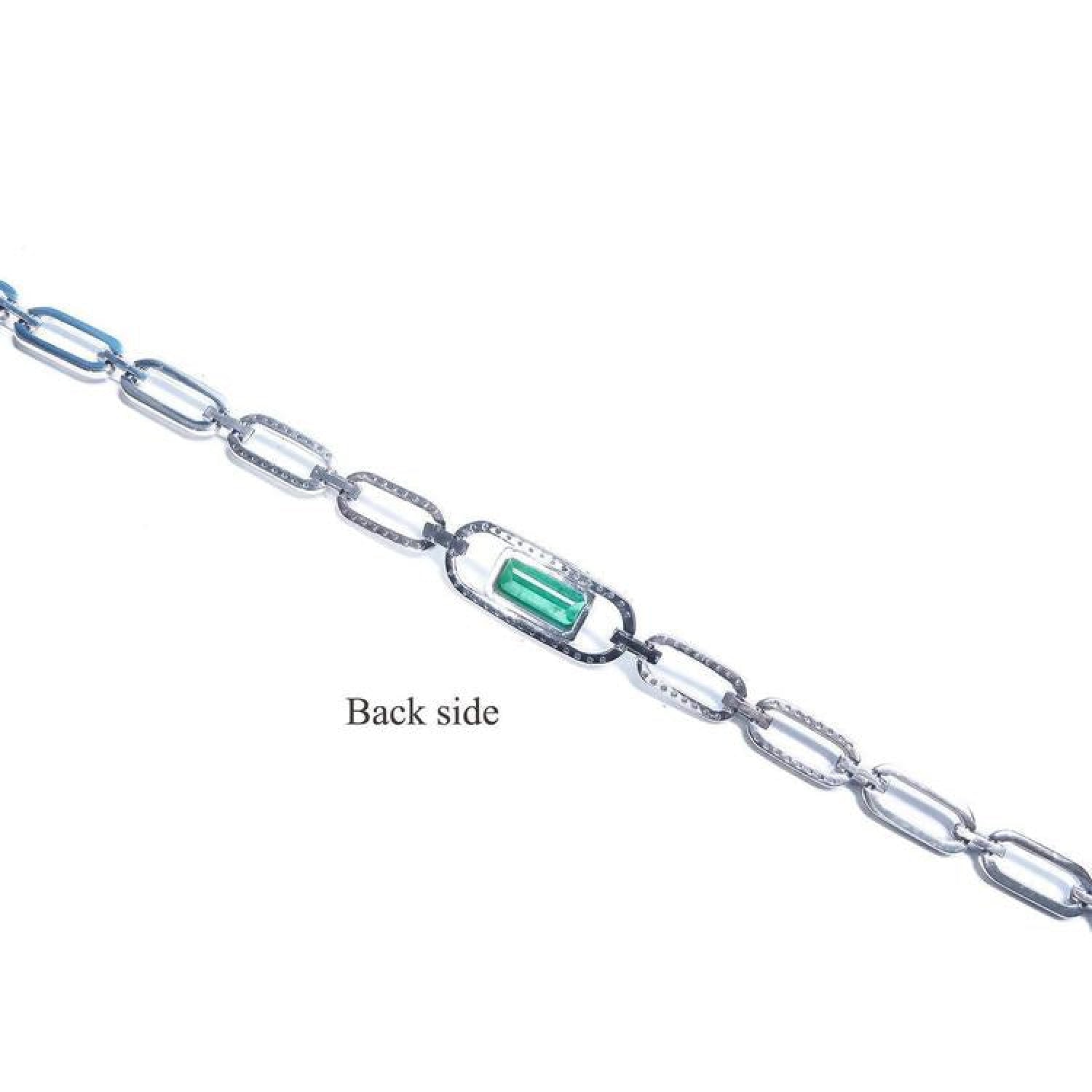 Back side of a 14K white gold paper clip bracelet with a medium deep bluish-green emerald.