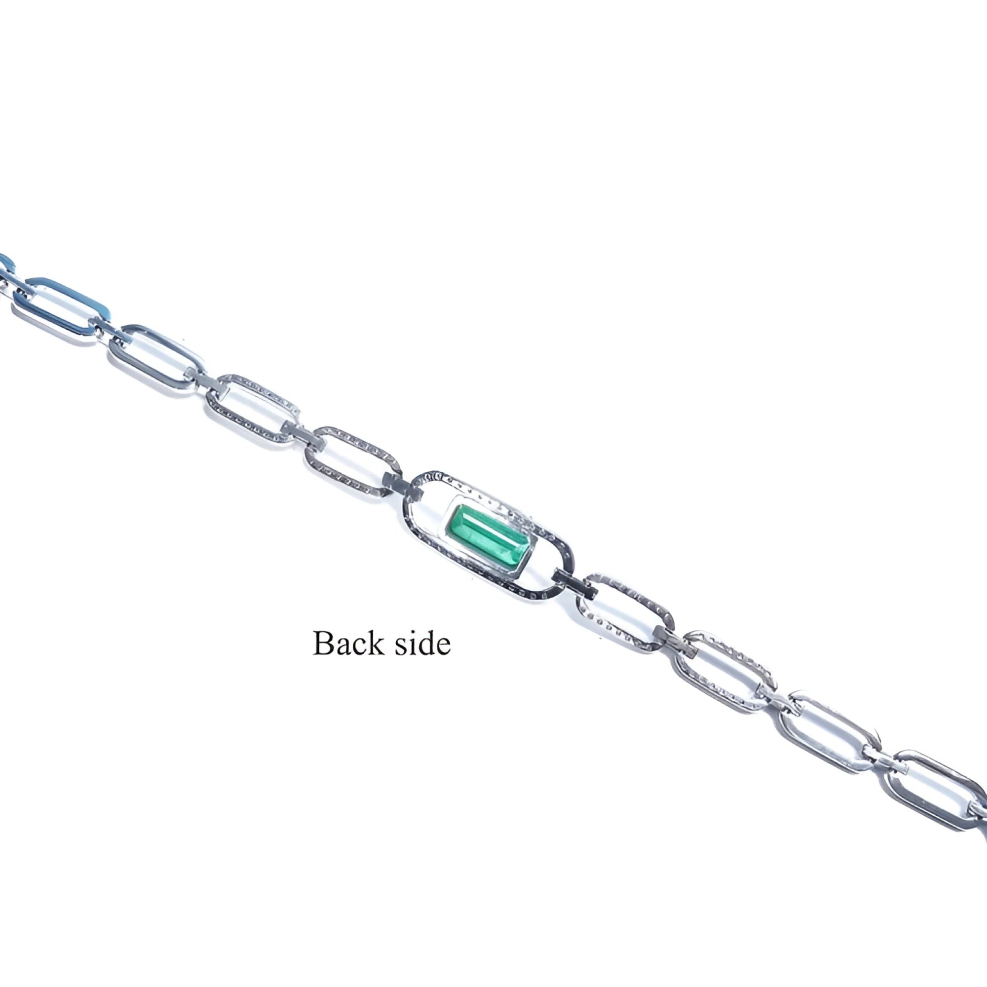 Back side of a 14K white gold paper clip bracelet with a medium deep bluish-green emerald.
