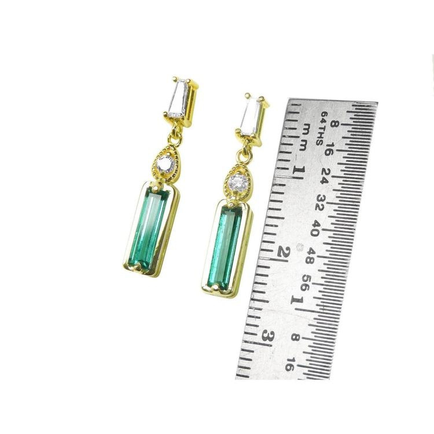 14K gold stud earrings with baguette emeralds, pear-shaped diamond extensions, and tapered baguette diamonds.