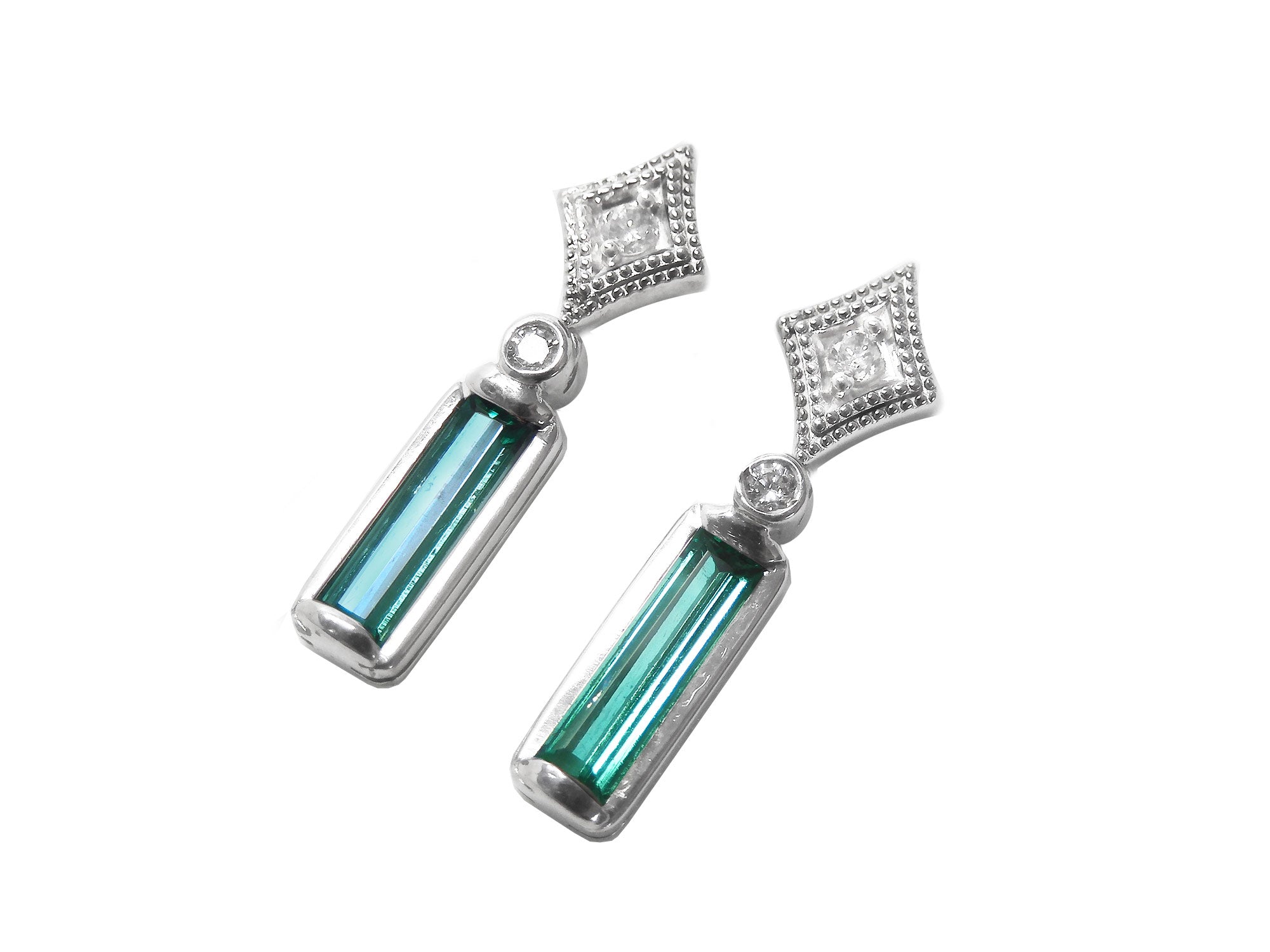 Pair of earrings with baguette cut natural emeralds and diamond tops on a left side profile view