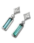 Pair of earrings with baguette cut natural emeralds and diamond tops on a left side profile view