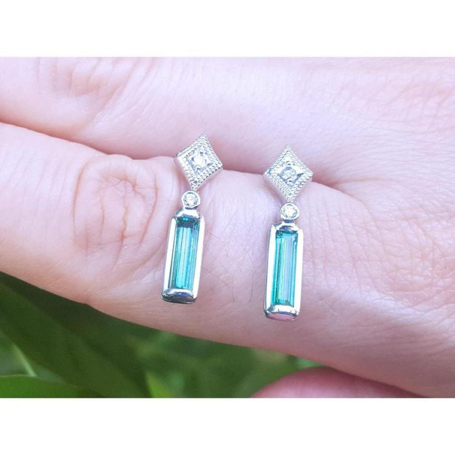 14K white gold emerald baguette and diamond stud earrings, featuring sparkling Colombian emeralds.
