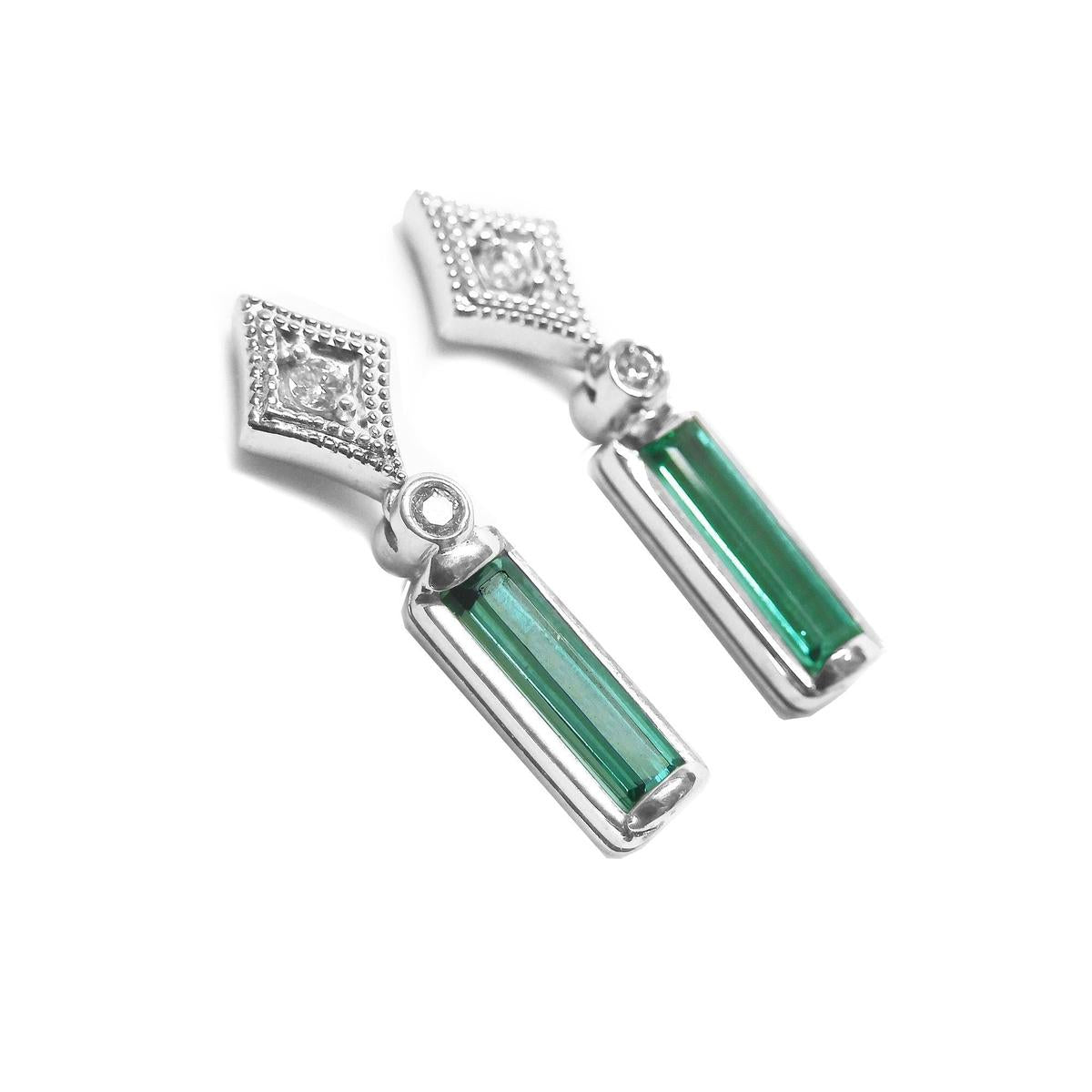 14k white gold baguette cut emerald earrings with accent diamonds on a right-side profile gallery view