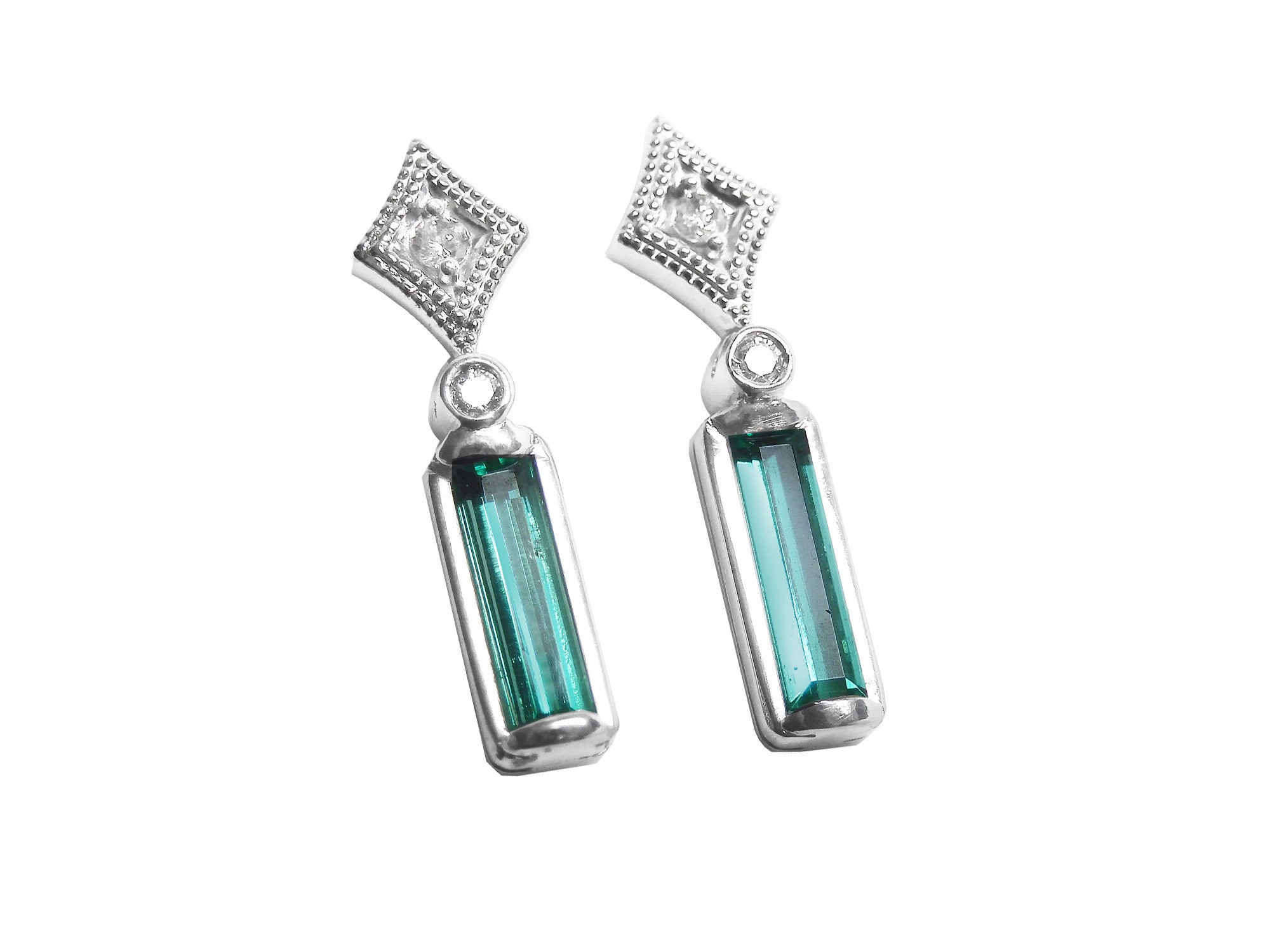 Pair of baguette cut emerald earrings and diamond accents on a top right-side position