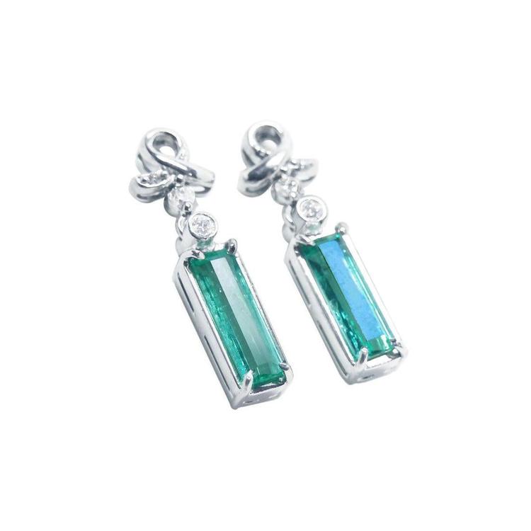 Pair of baguette cut natural emerald earrings made of 14k white gold.