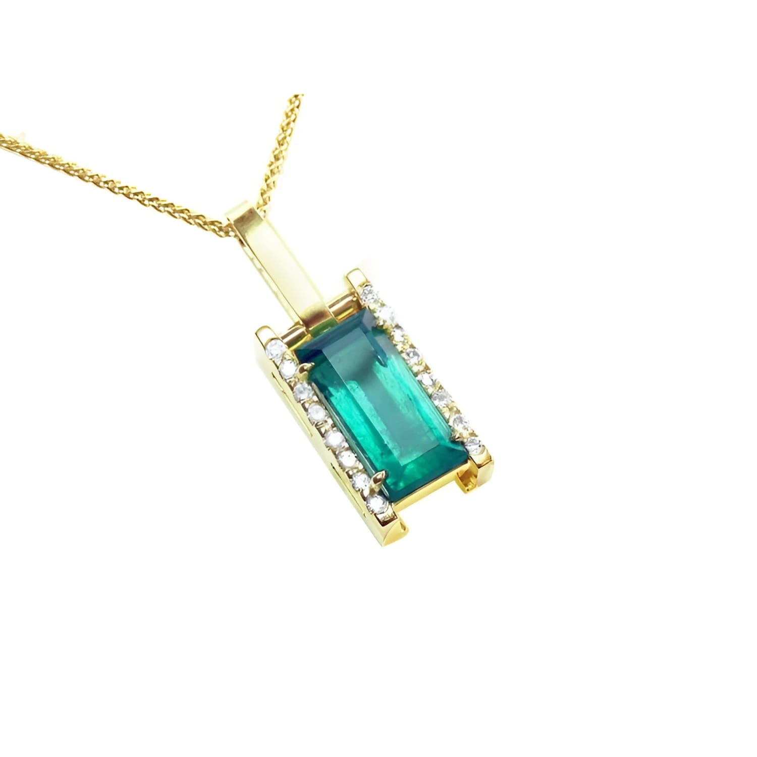 A yellow gold baguette cut emerald pendant with diamond accents topside view.