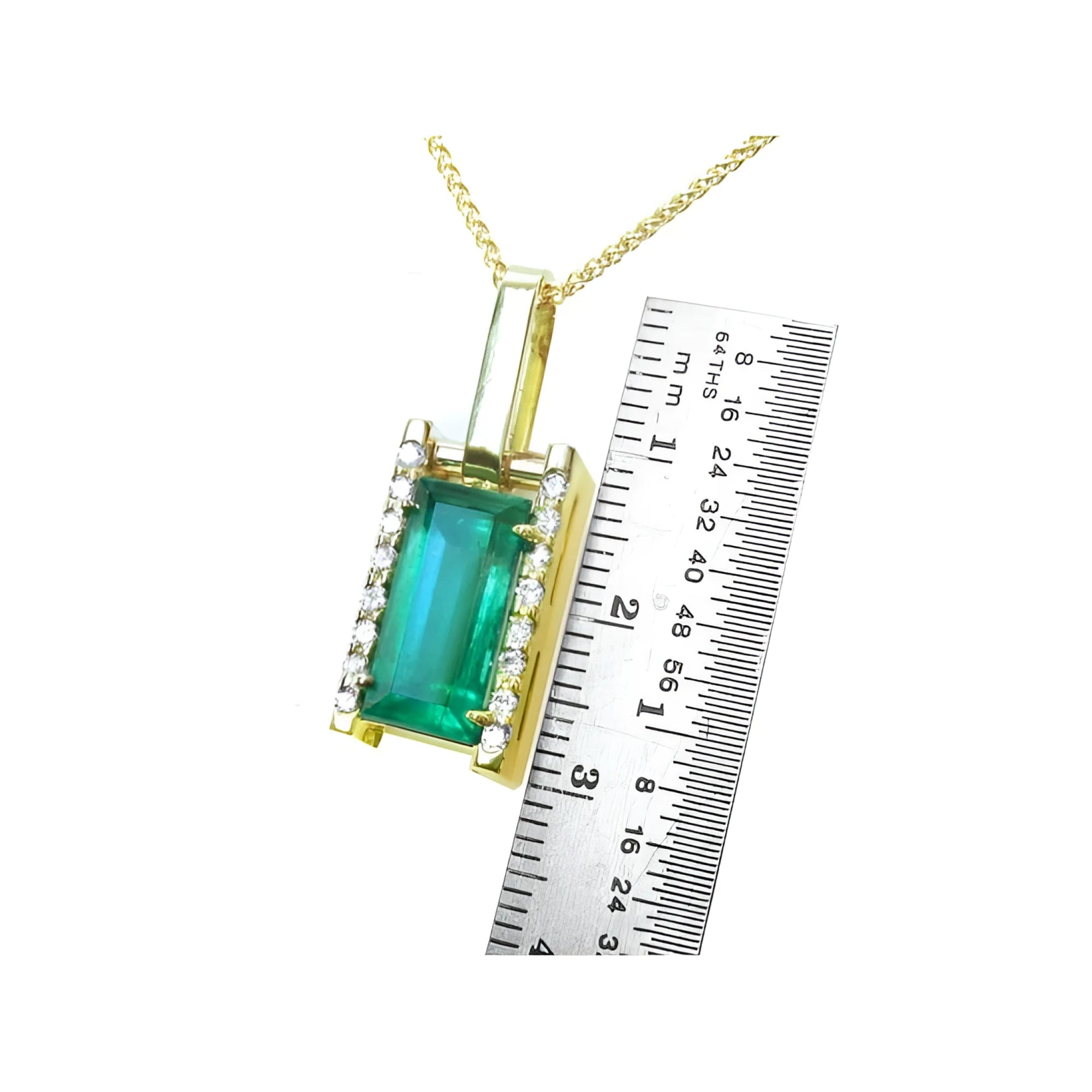 Baguette cut emerald pendant in 18K yellow gold with diamond accents, shown next to a ruler.