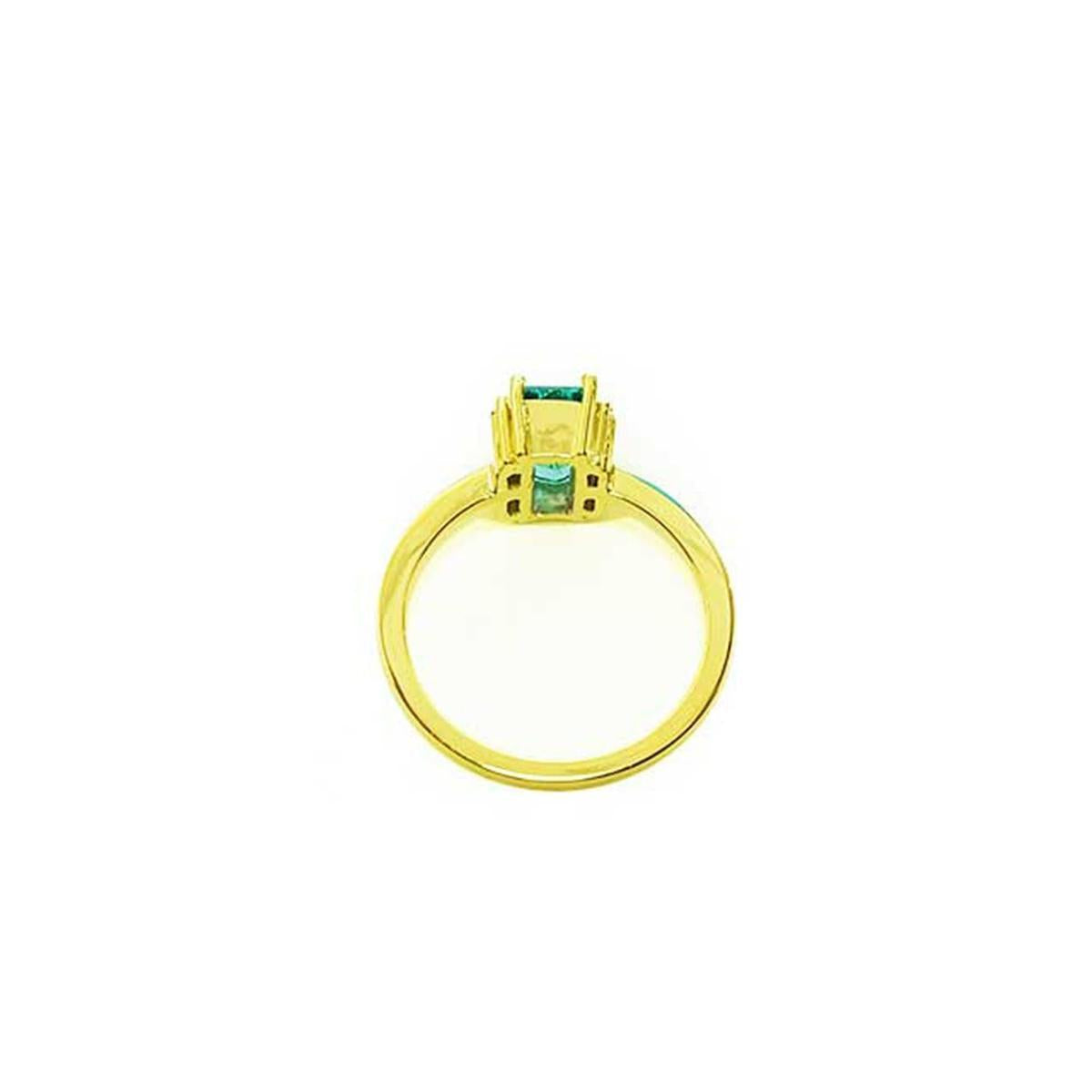 The underside view of a baguette cut emerald and diamond ring.