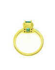 The underside view of a baguette cut emerald and diamond ring.