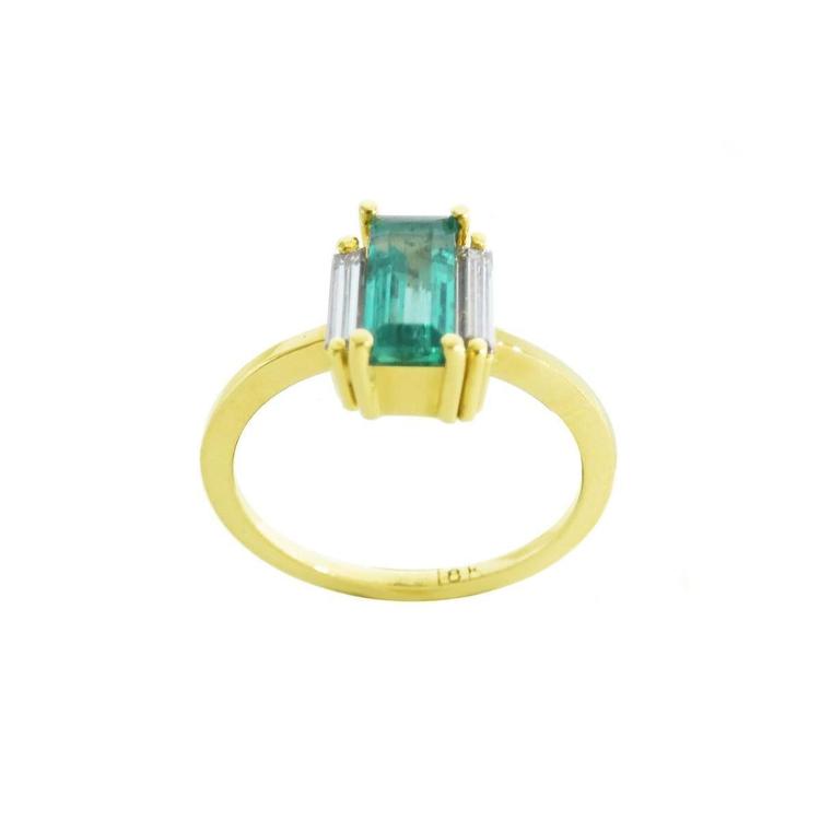 18K yellow gold ring with a baguette-cut emerald centerpiece and two baguette diamonds on each side.