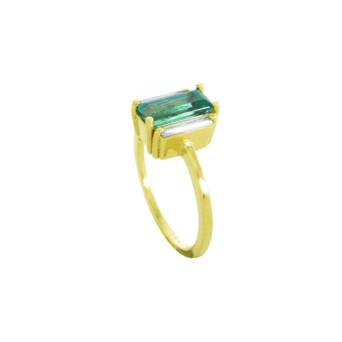 A 18k yellow gold ring with a baguette cut emerald and diamond on a half side profile position.