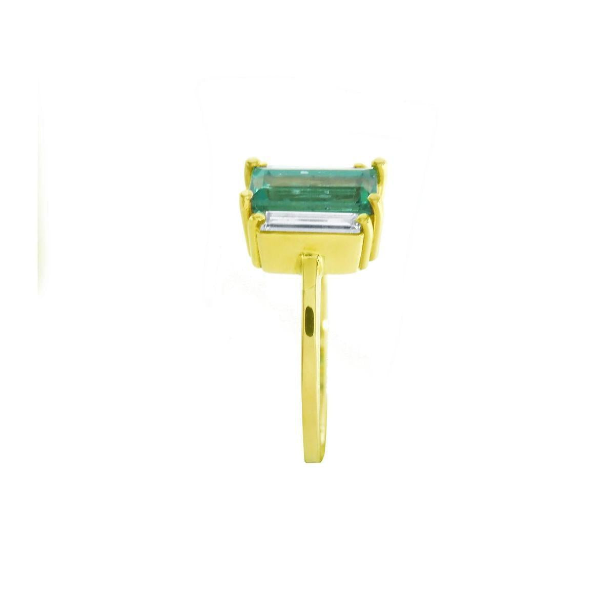 A yellow gold natural emerald and side baguette diamond ring displaying the side profile top and band view.