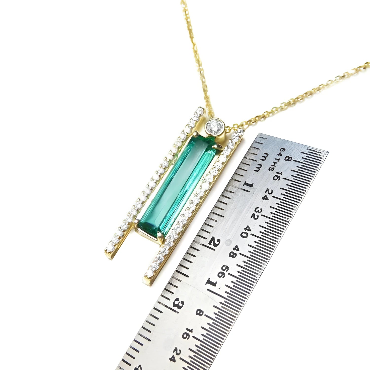 14K yellow gold necklace with a baguette-cut emerald, accent diamonds, and a sliding tube bail.