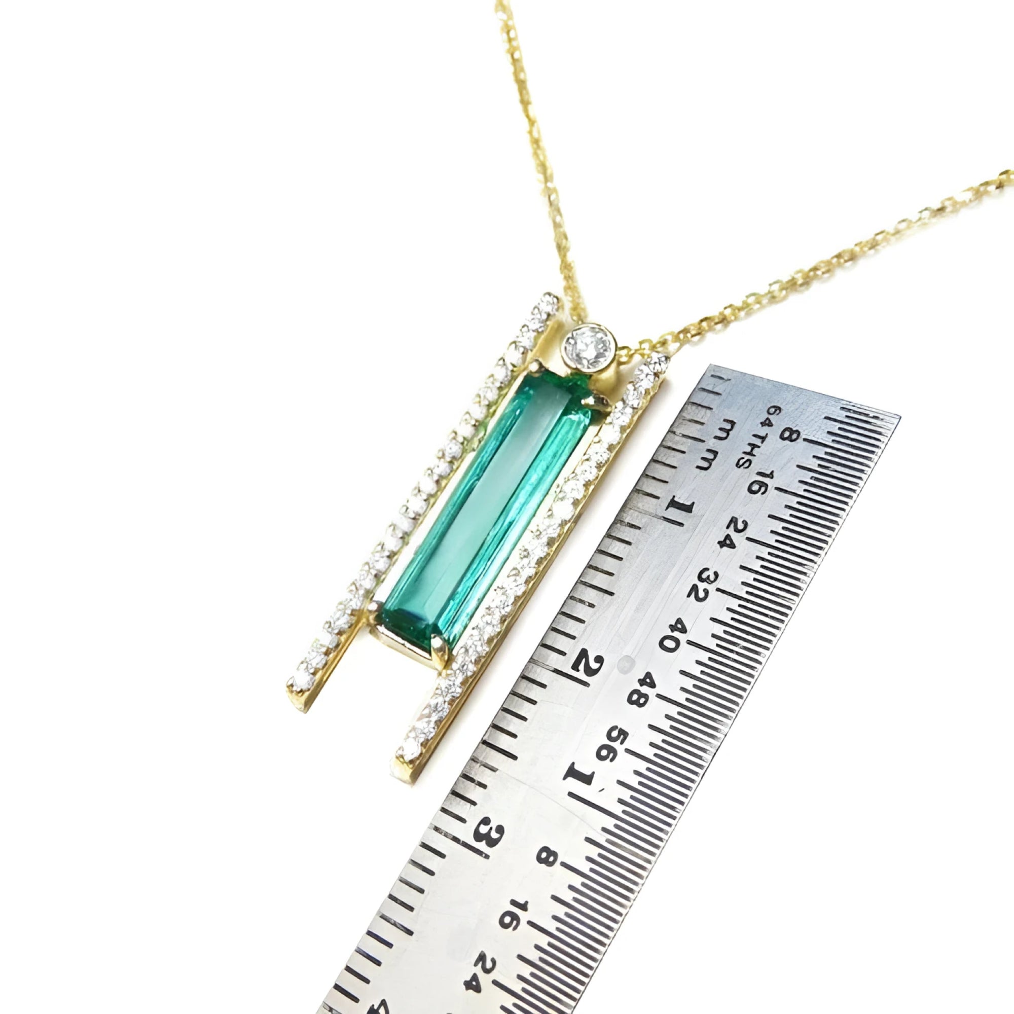14K yellow gold necklace with a baguette-cut emerald, accent diamonds, and a sliding tube bail.