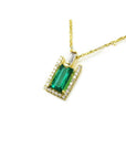 14K yellow gold baguette emerald pendant with diamond halo and bail on a delicate chain.